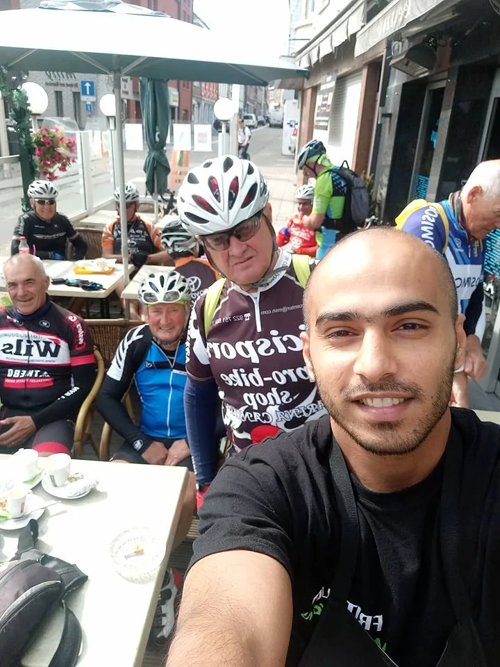 Een selfie op het terras van Frituur Madelyn: iemand van de zaak met een groep fietsers met helm
